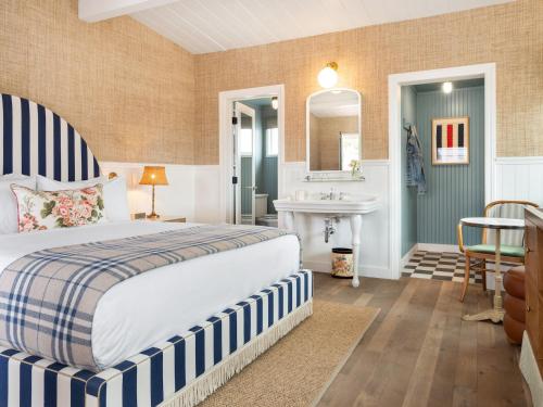 a bedroom with a bed and a bathroom with a sink at Le Petit Pali Laguna Beach in Laguna Beach