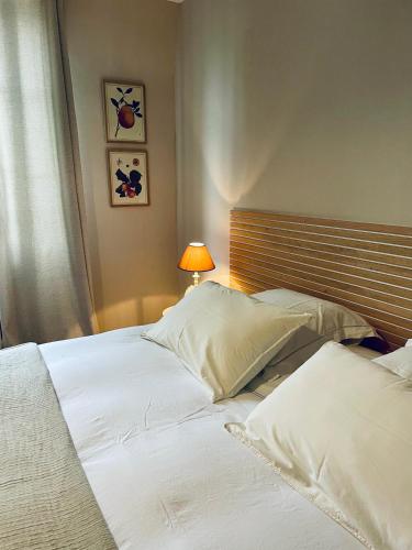two white beds in a bedroom with a lamp at Belle Fontaine in Bourges