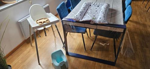 a glass table with a mirror and some blue chairs at Le Bleu d 'Audinghen in Audinghen