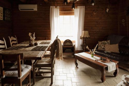 a living room with a wooden table and a couch at Wild&Free Private Lake in Nagycsepely