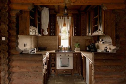 a kitchen with wooden cabinets and a stove top oven at Wild&Free Private Lake in Nagycsepely