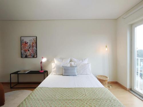 a bedroom with a large white bed and a window at Douro Valley View Apartments in Armamar
