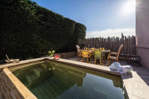- une piscine avec une table et des chaises à côté dans l'établissement Superbe appartement de haut standing, à Saint-Tropez