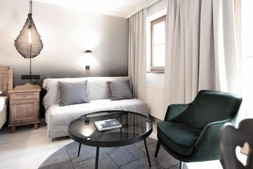 a living room with a couch and a table and a chair at Berg-Leben in Grossarl