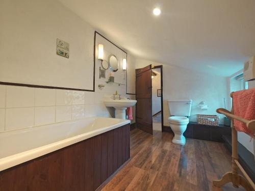 a bathroom with a tub and a toilet and a sink at 2 Hope Cottage in Spilsby