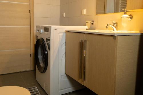 een badkamer met een wasmachine en een wastafel bij Dream Villa in Kokkíni Khánion