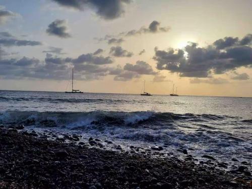 a beach with boats in the water and the ocean at Il Nido in Stromboli