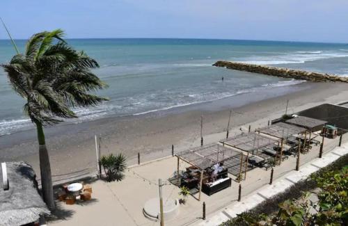 une plage avec un palmier et l'océan dans l'établissement Edificio Poseidon Depto. Vista Lateral al Mar, à Manta