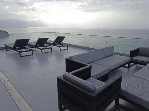 un groupe de chaises et de canapés installés sur un toit dans l'établissement Edificio Poseidon Depto. Vista Lateral al Mar, à Manta