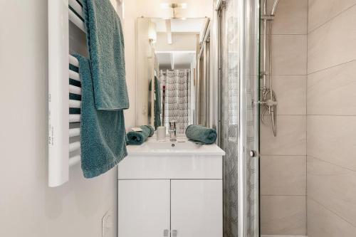 une salle de bain blanche avec un lavabo et une douche dans l'établissement Naturistecapdagde village naturiste Nude, au Cap d'Agde