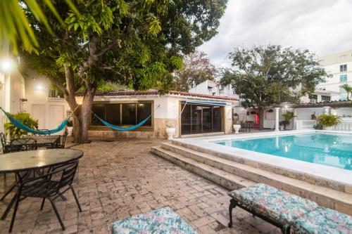 a pool with a table and chairs next to a house at Casa de playa Vistamare in Santa Marta