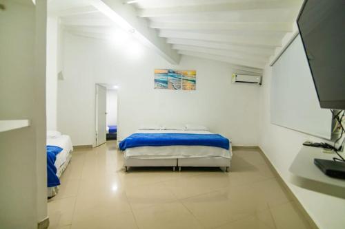 a room with two beds and a tv in it at Casa de playa Vistamare in Santa Marta