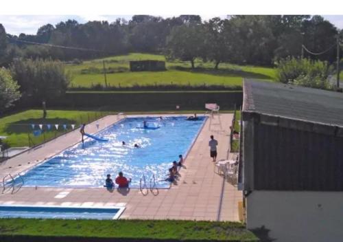 une grande piscine avec des gens dans l'eau dans l'établissement Camping Baroudeurs, à Lagraulière