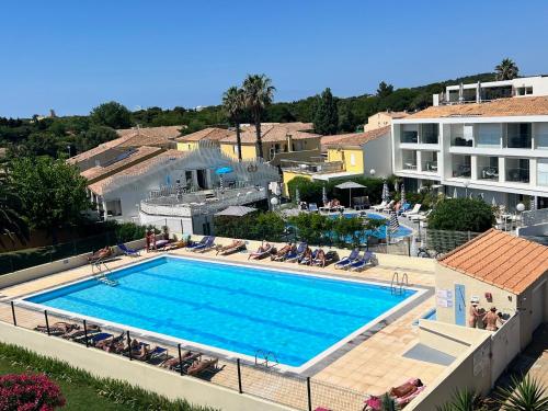 une image d'une piscine dans un complexe hôtelier dans l'établissement Naturistecapdagde village naturiste Nude, au Cap d'Agde