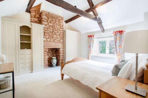 a bedroom with a large bed and a fireplace at Stunning Country Farm House between Bristol & Bath in Bristol