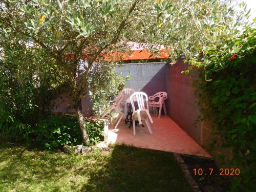 une terrasse avec 2 chaises et un arbre dans l'établissement l'olivier, à Bouguenais