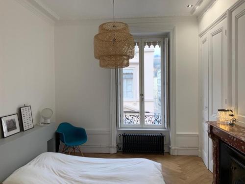 - une chambre avec un lit, une chaise bleue et une fenêtre dans l'établissement Ainay - Luxury apartment - 2 bedroom and 2 bathroom, à Lyon