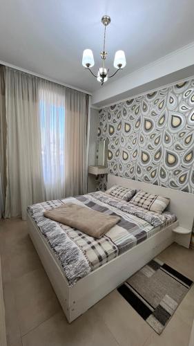 a bedroom with a large bed with a wall at Apartment Katya in Batumi