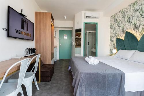 a hotel room with a bed and a table and chairs at Studio - Setin Downtown Estação Luz - Sou House in São Paulo