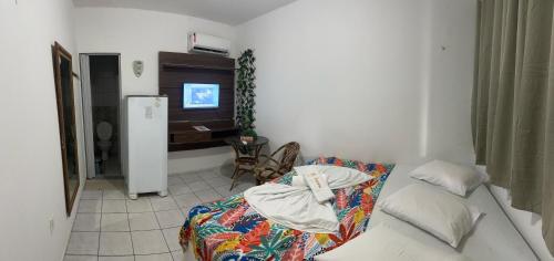 a small room with a bed and a television at Pousada Iracema Centro in Fortaleza