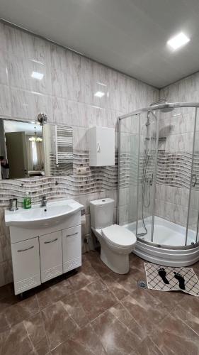 a bathroom with a toilet and a sink and a shower at Apartment Katya in Batumi