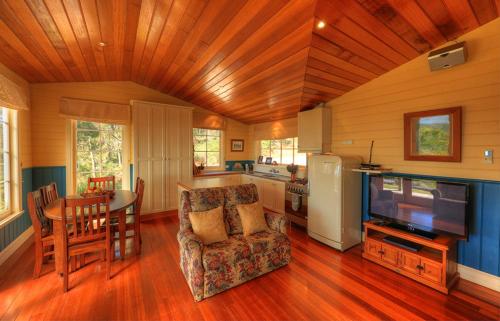 a living room with a kitchen and a dining room at Island View Spa Cottage in Smithton