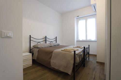 a white bedroom with a bed and a window at Marina House - Iulm Navigli San Paolo in Milan
