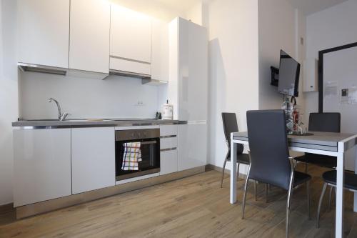 a kitchen and dining room with a table and a stove at Marina House - Iulm Navigli San Paolo in Milan