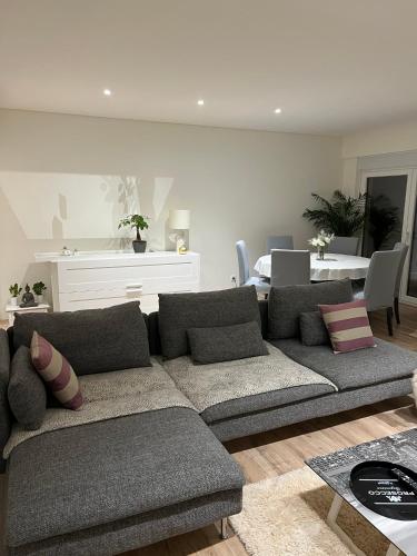 a living room with a couch and a dining room at Modern Big Room with Balcony in New Apartment in Montijo