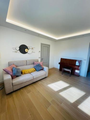 a living room with a couch and a piano at Holiday Flat in Villa San Gregorio with pool in Melazzo