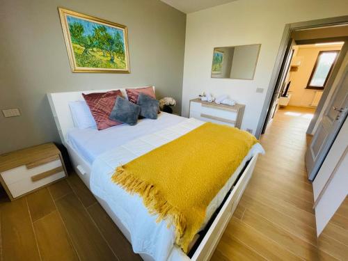 a bedroom with a large bed with a yellow blanket at Holiday Flat in Villa San Gregorio with pool in Melazzo