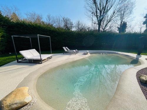a swimming pool with a chair and a swing at Holiday Flat in Villa San Gregorio with pool in Melazzo