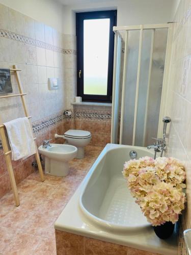 a bathroom with a tub and a toilet and a sink at Holiday Flat in Villa San Gregorio with pool in Melazzo