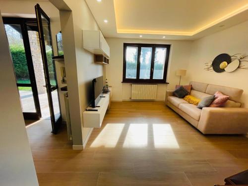 a living room with a couch and a television at Holiday Flat in Villa San Gregorio with pool in Melazzo