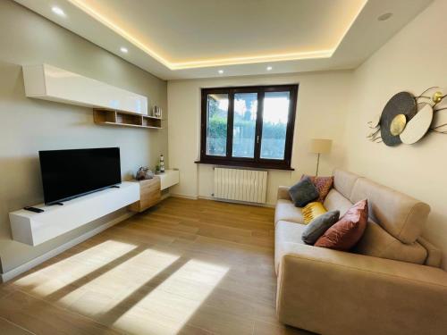 a living room with a couch and a flat screen tv at Holiday Flat in Villa San Gregorio with pool in Melazzo