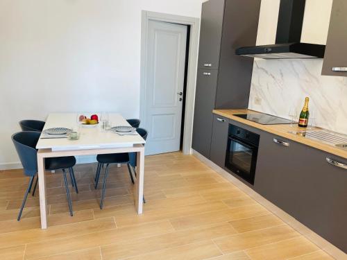 a kitchen with a white table and some chairs at Holiday Flat in Villa San Gregorio with pool in Melazzo