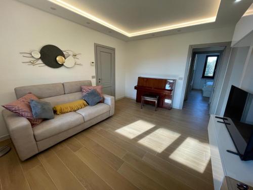 a living room with a couch and a piano at Holiday Flat in Villa San Gregorio with pool in Melazzo