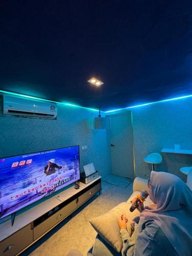 a man sitting on a couch in front of a tv at StarSuiteAC at Arte Cheras with Soundproof Karaoke, Billiard, Air-Hockey in Kuala Lumpur