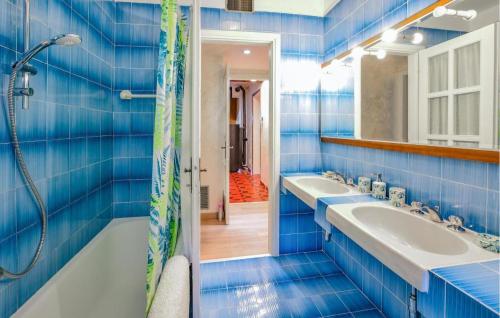 baño de azulejos azules con 2 lavabos y ducha en Shelter in the Woods Silence and Harmony, en Bordogna