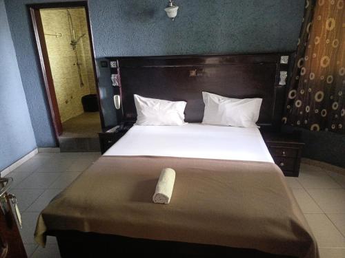 a bedroom with a bed with a roll on it at HOTEL GEORGES 5 Bénin in Cotonou