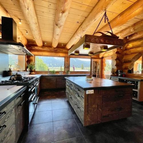une grande cuisine avec des plafonds en bois et des comptoirs en bois dans l'établissement Chalet de montagne 10 voyageurs prés de Font-Romeu 1600m, à La Cabanasse