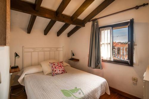 リャネスにあるApartamento La Posada del Cuetuのベッドと窓のある寝室