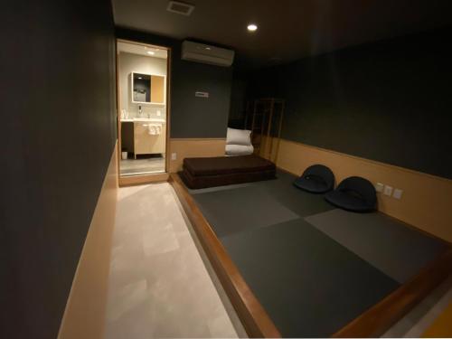 a small room with a bed and a bathroom at My Home Inn Sennan, Onosato in Ozaki