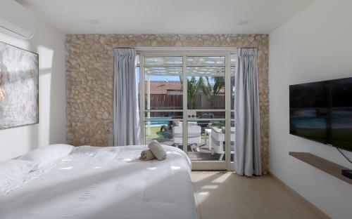 TV a/nebo společenská místnost v ubytování Villa Yotam 4BR Heated pool וילה יותם 4 חדרי שינה בריכה מחוממת