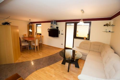 a living room with a white couch and a table at Holiday House Klemenčič in Bohinj