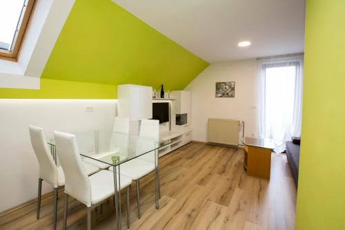 a dining room with a glass table and white chairs at Holiday House Klemenčič in Bohinj