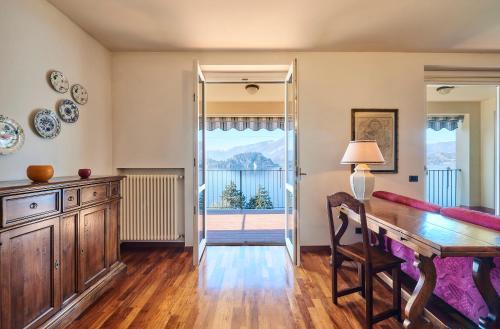 a dining room with a table and a mirror at Luxury Apartment with lake view near Varenna in Fiumelatte