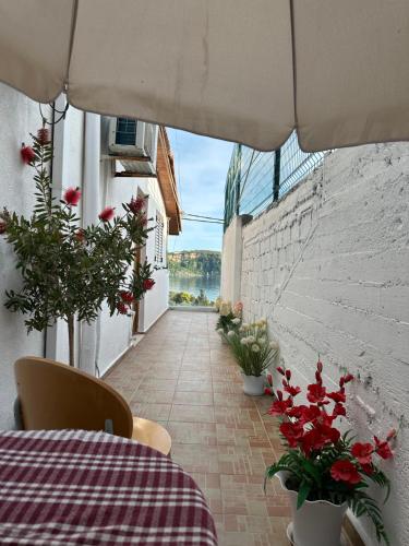 a table and chairs on a balcony with flowers at Lazaris kwstas Rooms in Himare