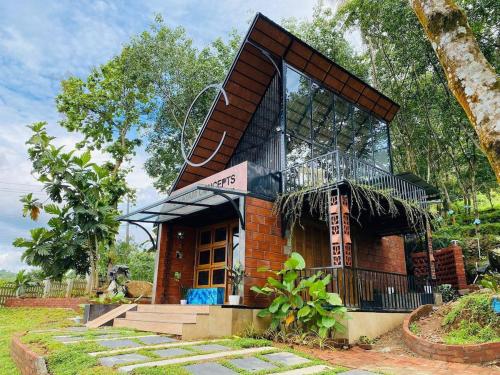 a small brick building with a balcony on top of it at NATURESGrandeur#ModernCabinTropical HABITAT#Kerala in Pathanāmthitta