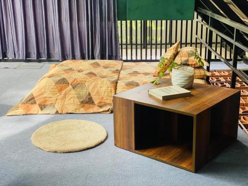 a bed and a table with a book on it at NATURESGrandeur#ModernCabinTropical HABITAT#Kerala in Pathanāmthitta
